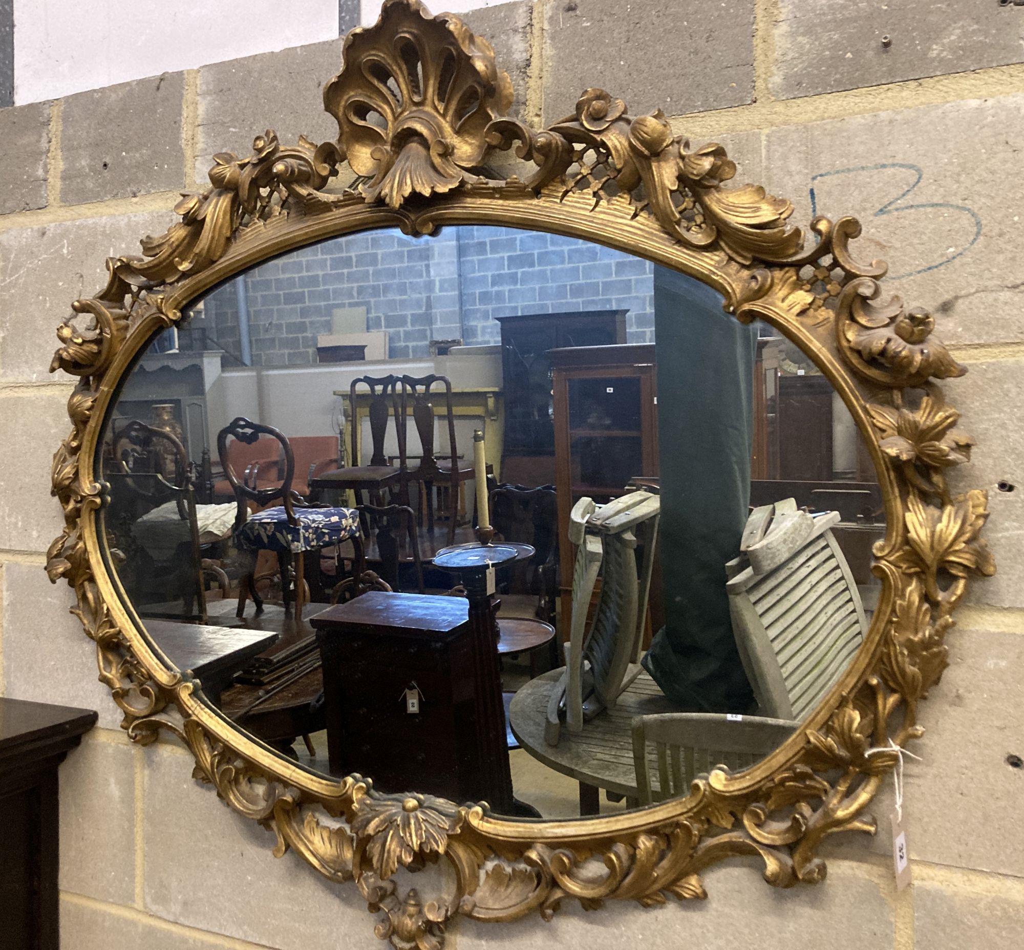 A Victorian ornate gilt oval wall mirror, width 110cm height 100cm